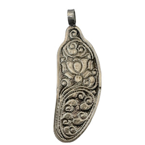 Silver pendant with intricate designs on a light silver background